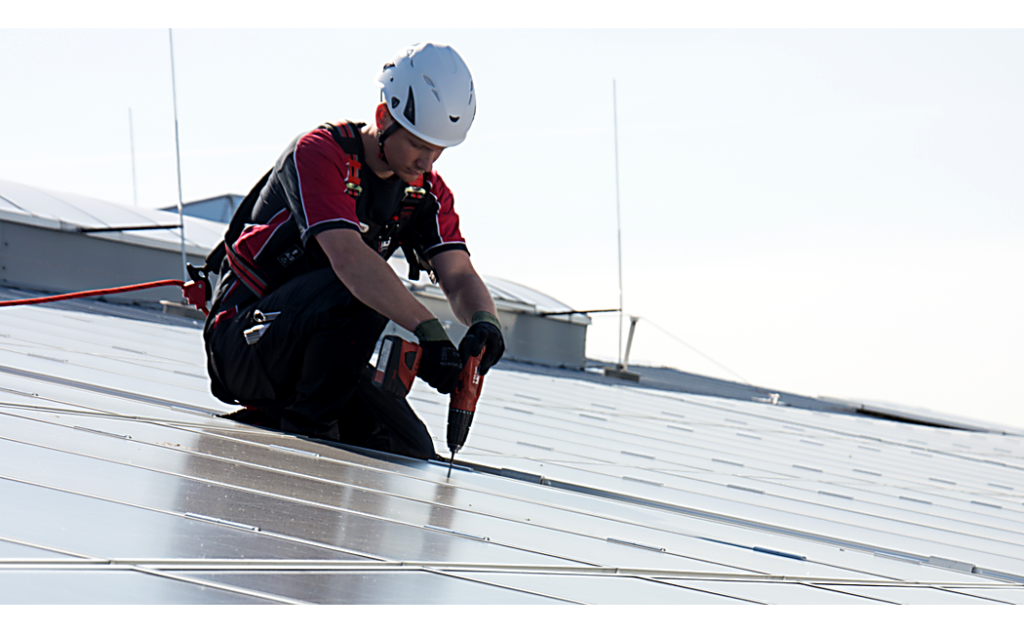 Medewerker bij het verzorging van een zonne-installatie beveiligt door ABS-Lock X-Solar ankerpunt