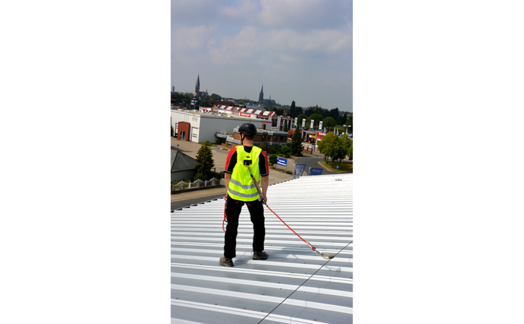 Foto van een dakwerker die een veiligheidsvest draagt met een geïntegreerd veiligheidsharnas.